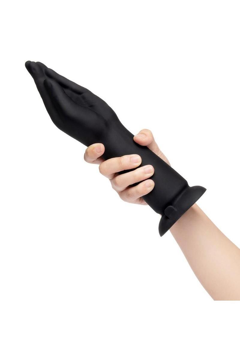 Black silicone glove being worn on a white background