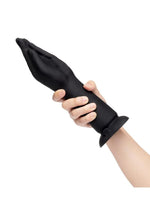 Black silicone glove being worn on a white background